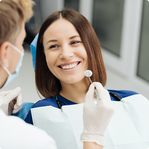 Female patient smiling at dentist during dental checkup