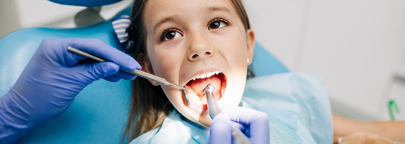Little girl having her teeth examined by a children's dentist in Fredericksburg