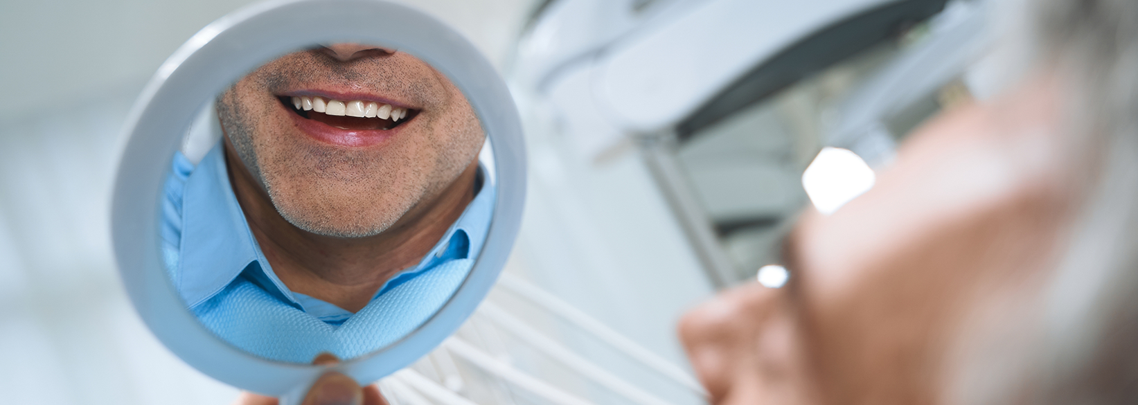 Man checking his smile in a mirror