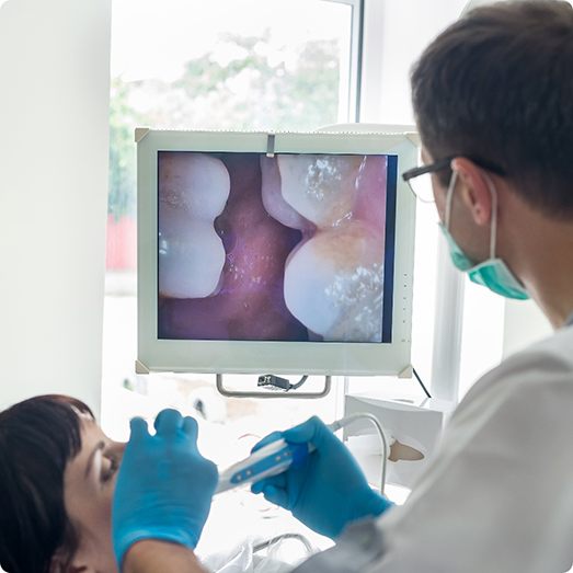 Dentist examining a patient's teeth with an intraoral camera