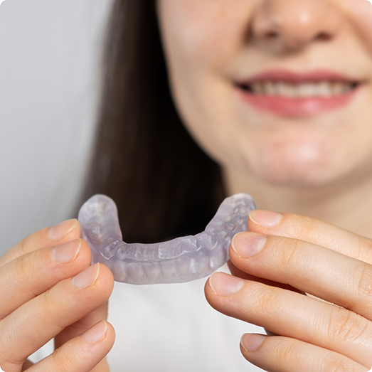 Close up of woman holding a clear nightguard