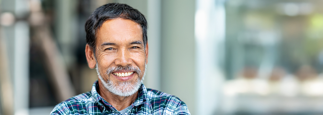 Bearded man in a blue plaid shirt smiling