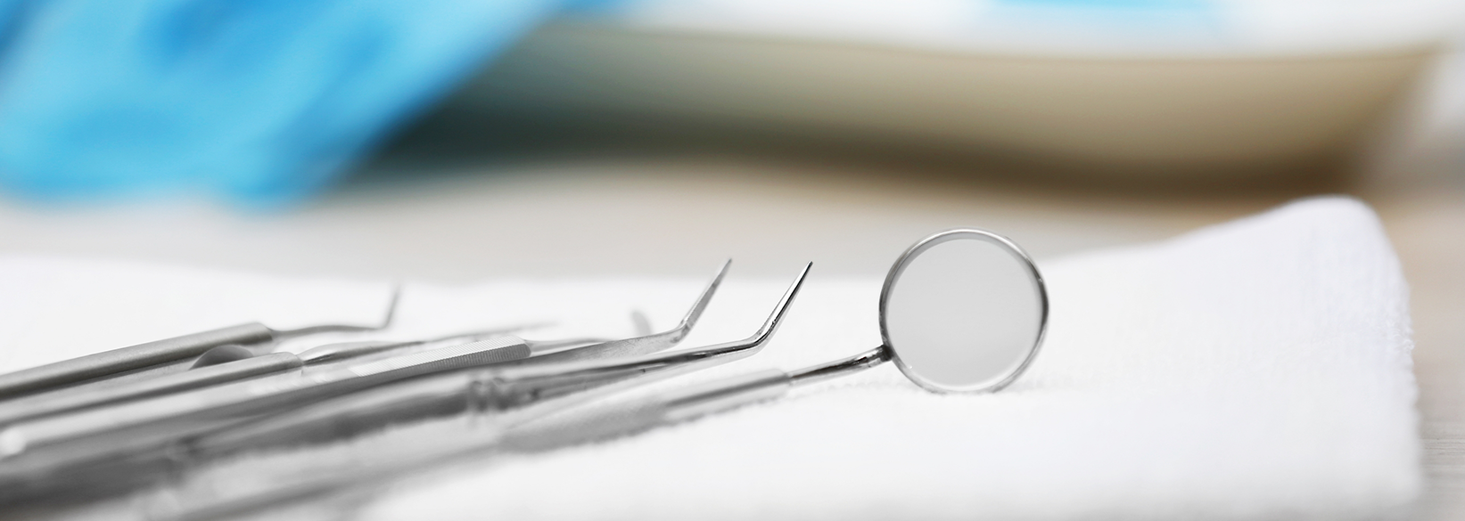 Close up of dental instruments lying on white cloth