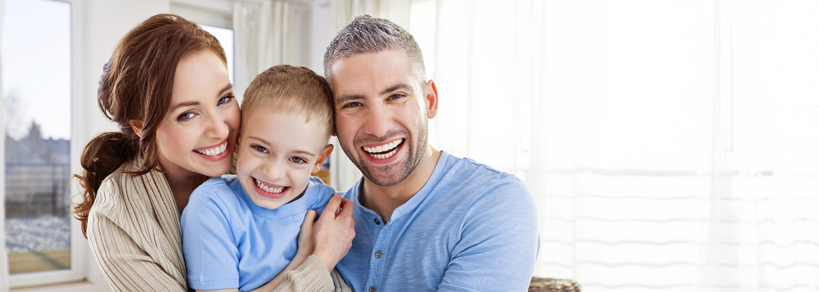 Mother and father smiling at home with their child